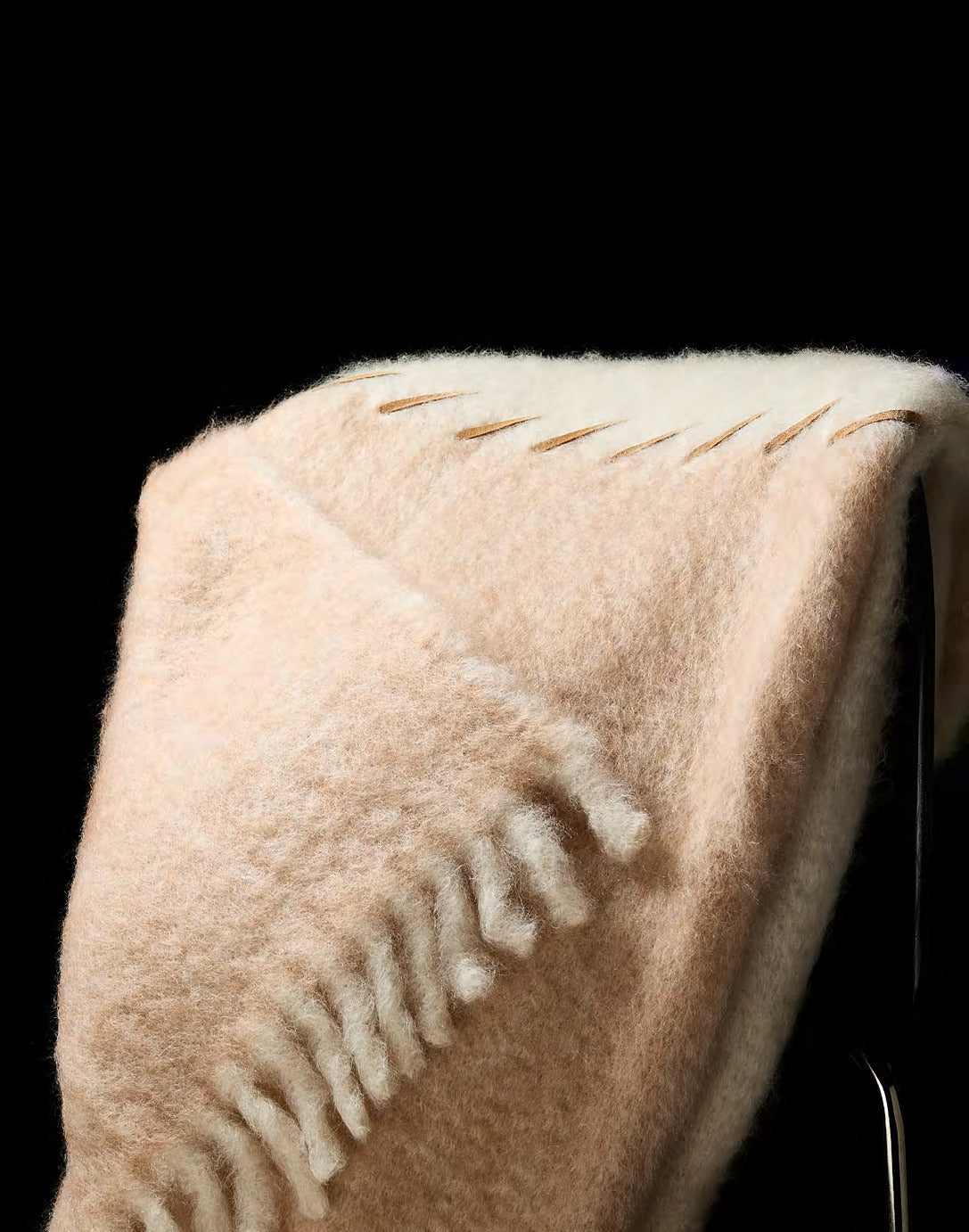 Detail van het suède stiksel op de Mantas Ezcaray Stitching mohairplaid in ecru en zalmbeige